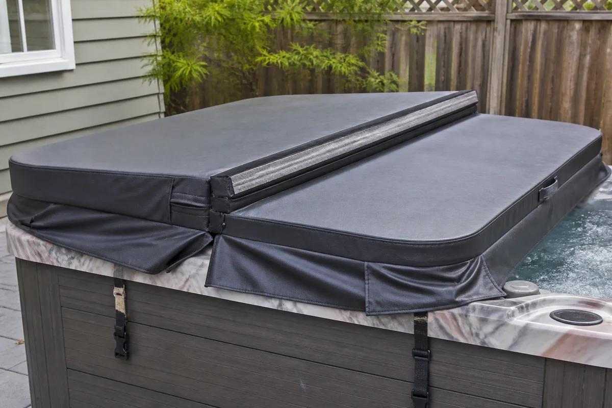 Fitted hot tub cover showing the hinge, skirt, and locking straps