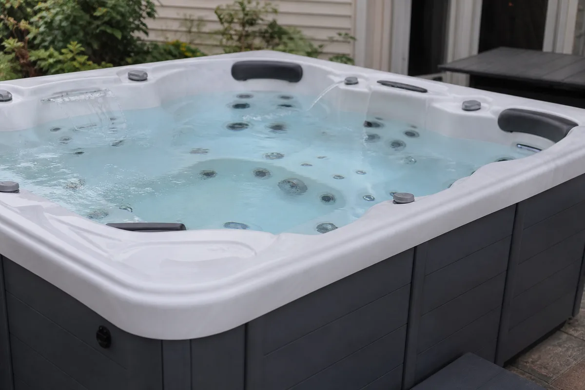 Residential hot tub with multiple jets and topside controls visible