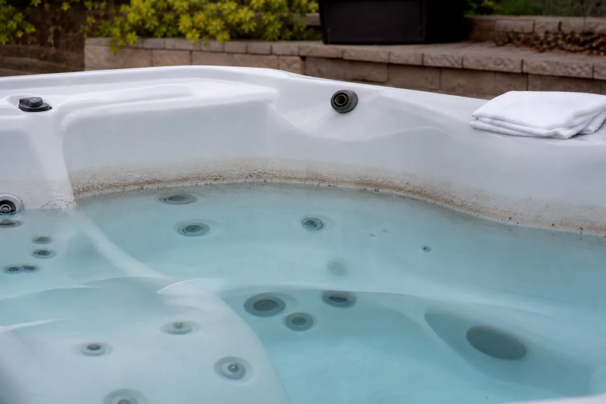 Brownish scum ring along the waterline of a residential hot tub